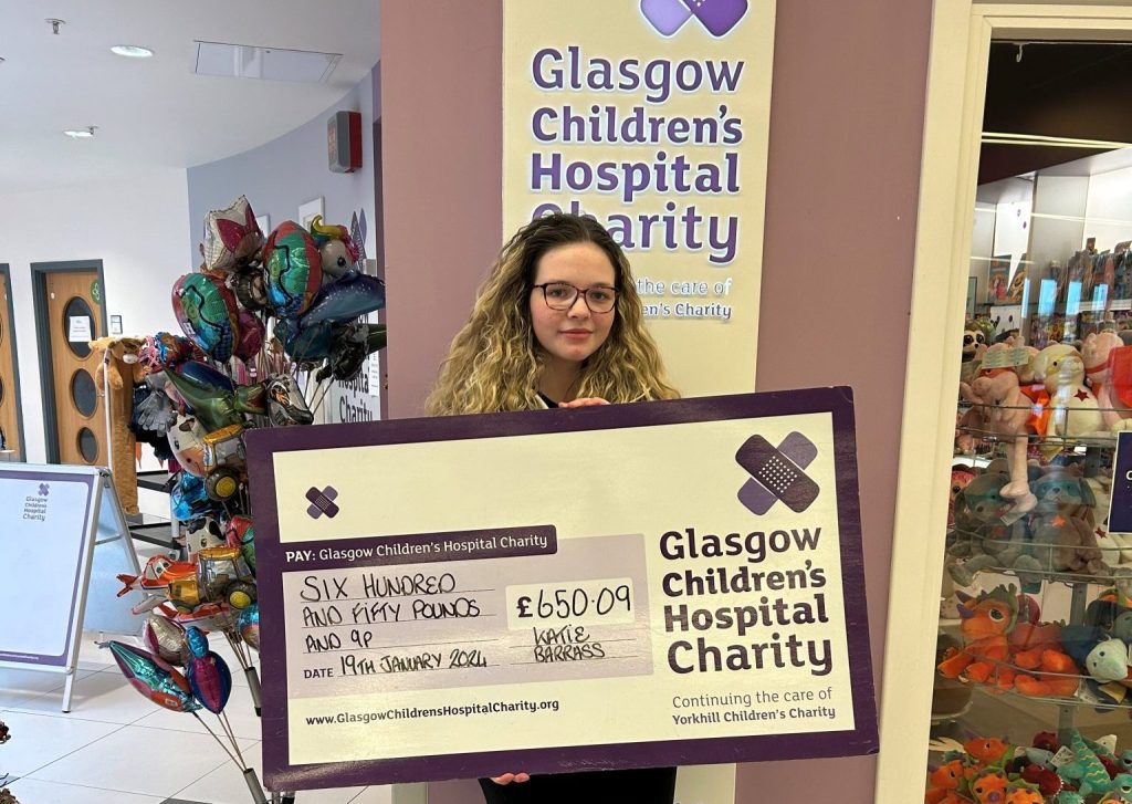 Young person Katie presenting cheque to Glasgow Children's Hospital Charity